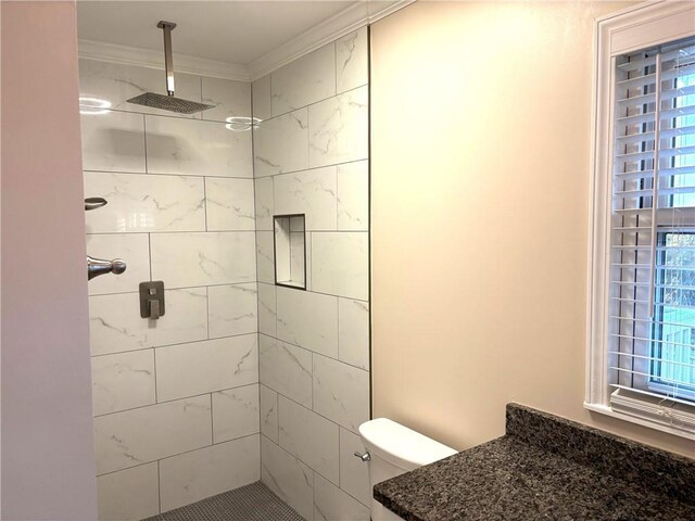 bathroom with tiled shower and crown molding