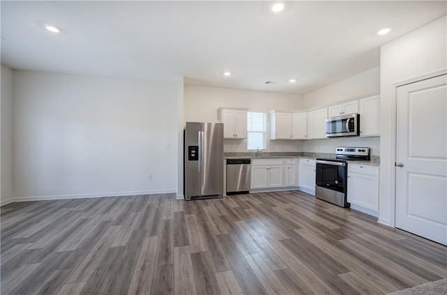 kitchen featuring white cabinetry, appliances with stainless steel finishes, sink, and light hardwood / wood-style flooring