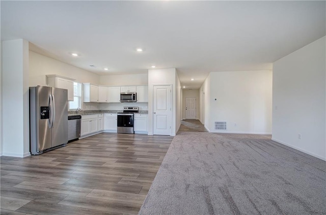 kitchen featuring white cabinetry, stainless steel appliances, sink, and wood-type flooring