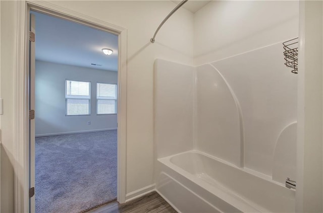 bathroom featuring hardwood / wood-style flooring and shower / washtub combination