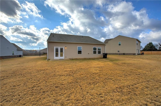 back of property with french doors and a lawn