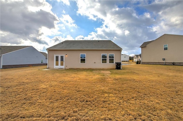 rear view of property featuring french doors and a lawn