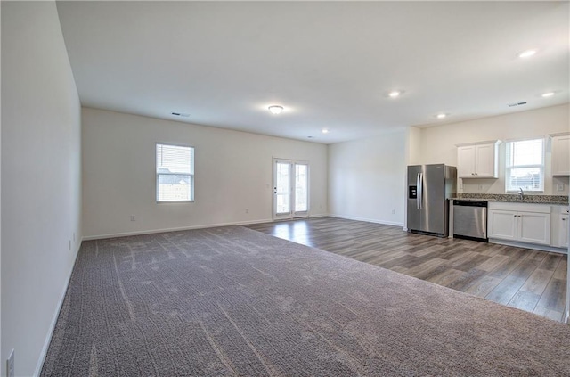 unfurnished living room featuring carpet flooring and sink