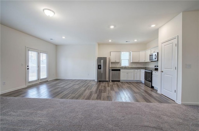 kitchen featuring stainless steel appliances, white cabinetry, and wood-type flooring