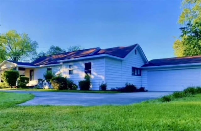 ranch-style home featuring a garage, driveway, and a front yard