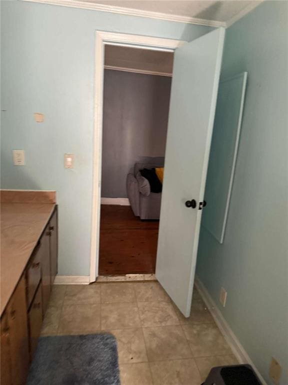 bathroom featuring ornamental molding, tile patterned flooring, vanity, and baseboards