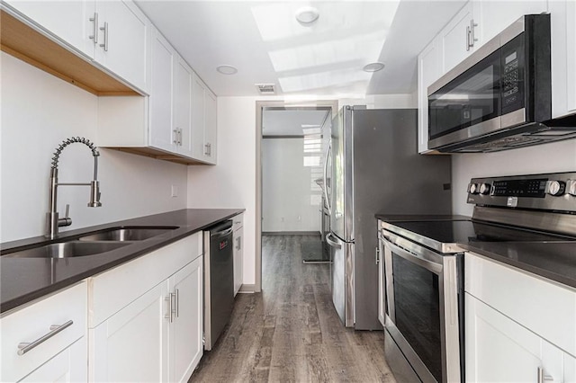 26 Ivy Pkwy NE, Atlanta, GA 30342 - kitchen with stainless steel appliances, a sink, wood finished floors, white cabinets, and dark countertops