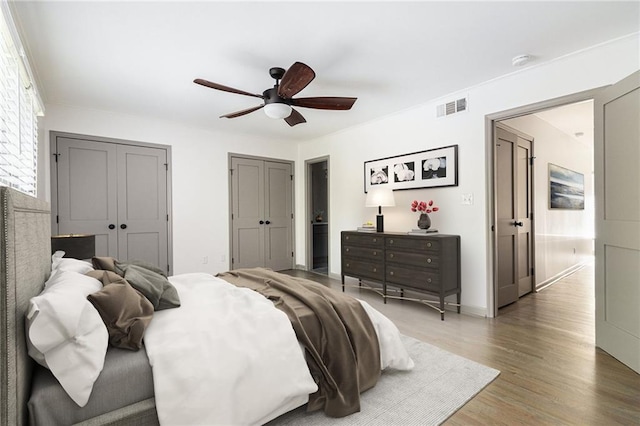 26 Ivy Pkwy NE, Atlanta, GA 30342 - bedroom featuring wood finished floors, two closets, ceiling fan, and baseboards