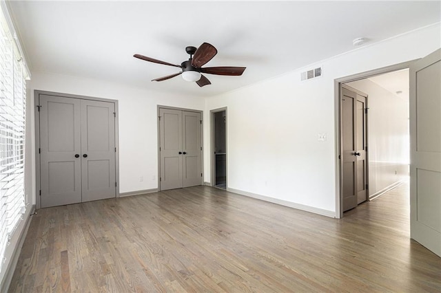 26 Ivy Pkwy NE, Atlanta, GA 30342 - unfurnished bedroom featuring light wood-style flooring, multiple closets, baseboards, and ceiling fan