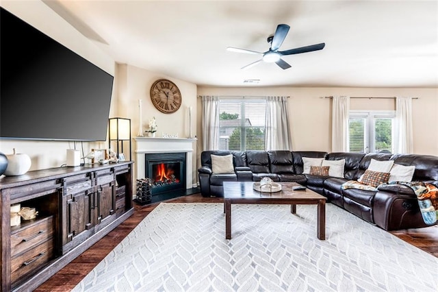 8553 Braylen Manor Dr, Douglasville, GA 30134 - living area featuring a ceiling fan, healthy amount of natural light, a glass covered fireplace, and dark wood-style flooring