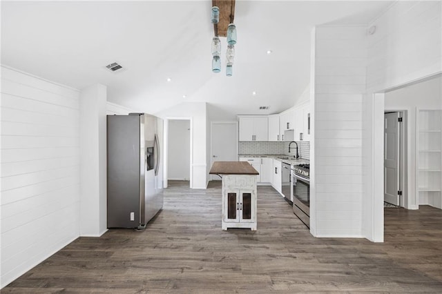 kitchen featuring visible vents, a kitchen island, a sink, stainless steel appliances, and dark wood-type flooring