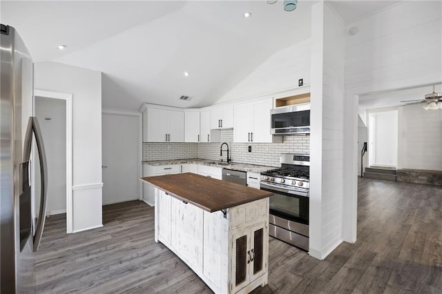 kitchen featuring stainless steel appliances, dark wood finished floors, butcher block counters, and white cabinets