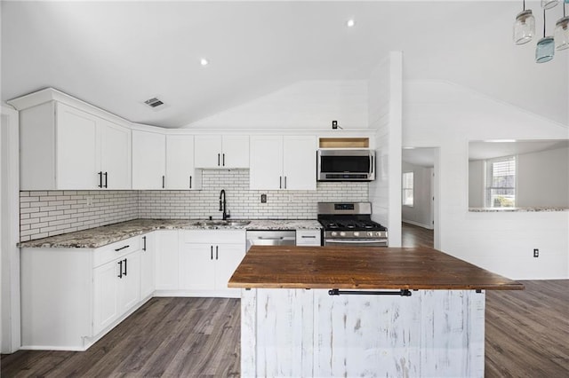 kitchen with visible vents, wooden counters, vaulted ceiling, appliances with stainless steel finishes, and a sink