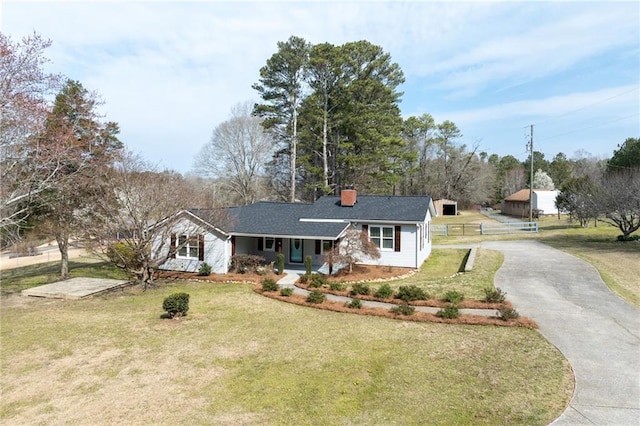 single story home featuring a front yard, fence, driveway, and a chimney