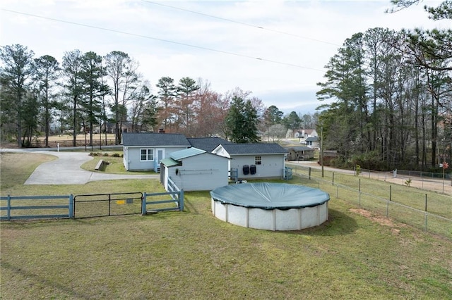 view of yard featuring a gate, a fenced in pool, and fence