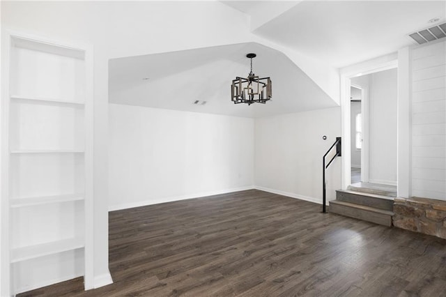 interior space with built in features, visible vents, lofted ceiling, dark wood-style flooring, and a chandelier