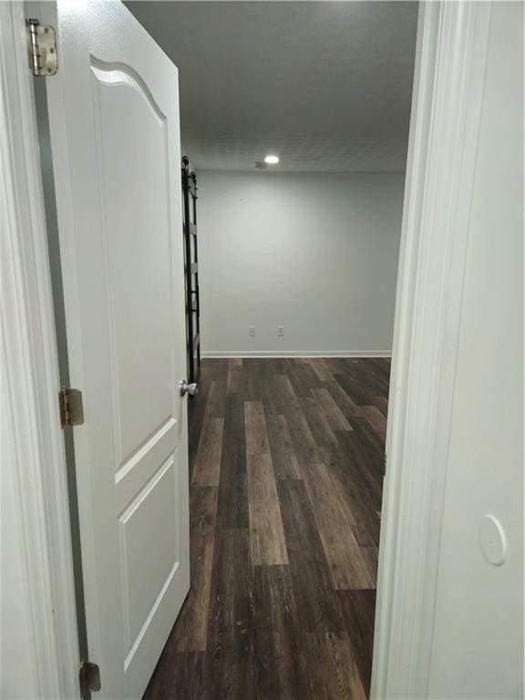 corridor with baseboards and dark wood-style flooring