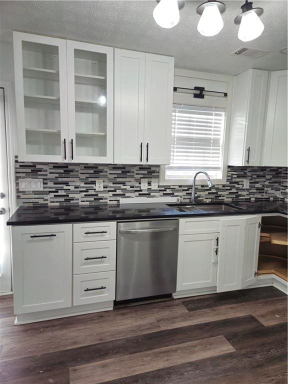 kitchen with dark countertops, dishwasher, dark wood-type flooring, and a sink