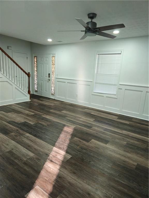 foyer with ceiling fan, stairway, recessed lighting, a decorative wall, and dark wood-style flooring