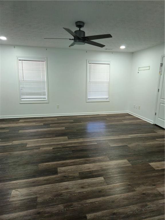 empty room featuring a textured ceiling, recessed lighting, baseboards, ceiling fan, and dark wood-style flooring