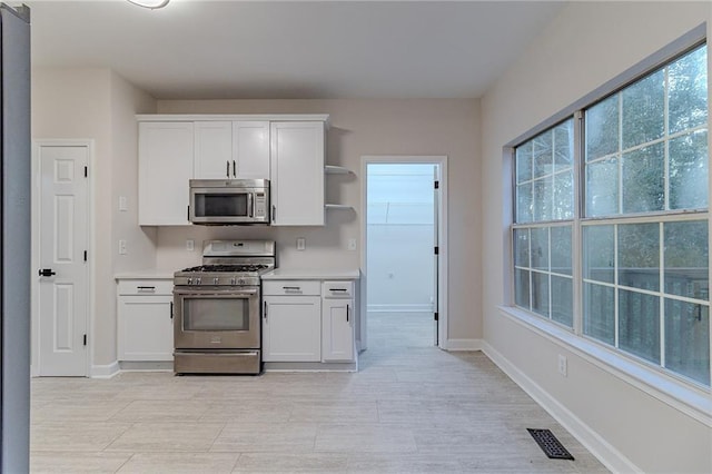 kitchen with white cabinets and appliances with stainless steel finishes