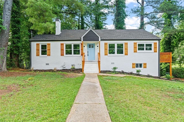 ranch-style home with crawl space, a chimney, a front lawn, and brick siding