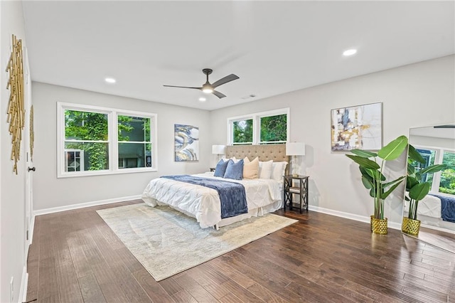 bedroom with multiple windows, dark wood-style flooring, and baseboards