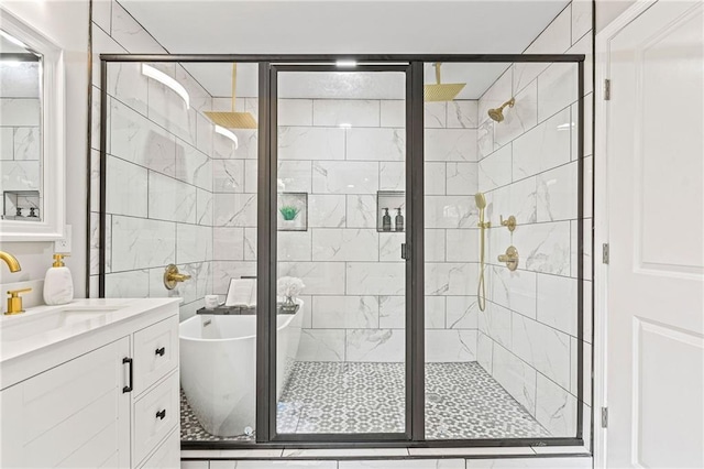 full bathroom featuring a freestanding tub, a stall shower, and vanity