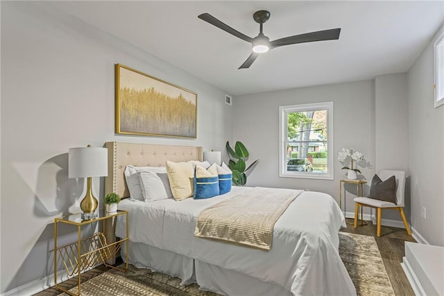 bedroom with dark wood-style flooring, visible vents, ceiling fan, and baseboards