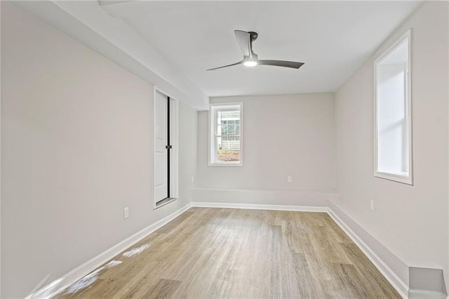 spare room featuring light wood-style floors, baseboards, and a ceiling fan