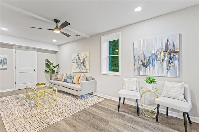 living area featuring baseboards, a ceiling fan, and wood finished floors