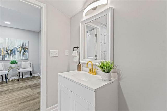 bathroom with baseboards, wood finished floors, and vanity