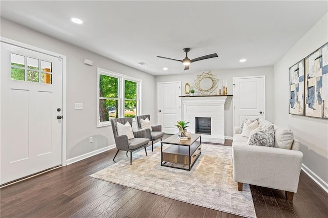 living room with dark wood-type flooring, recessed lighting, a fireplace, and baseboards