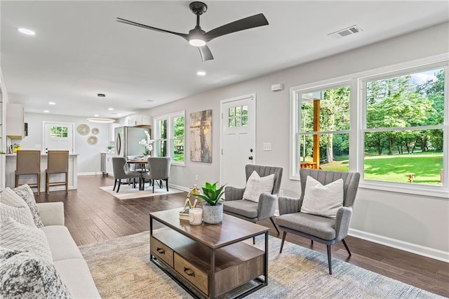 living area with ceiling fan, recessed lighting, visible vents, baseboards, and dark wood finished floors