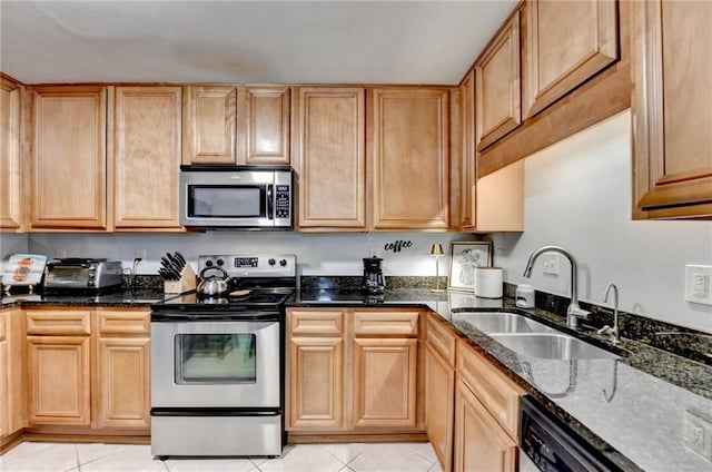 kitchen featuring sink, stainless steel appliances, dark stone counters, and light tile patterned flooring