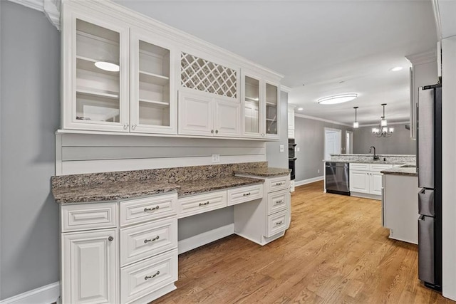 kitchen with dark stone counters, white cabinets, crown molding, hanging light fixtures, and appliances with stainless steel finishes