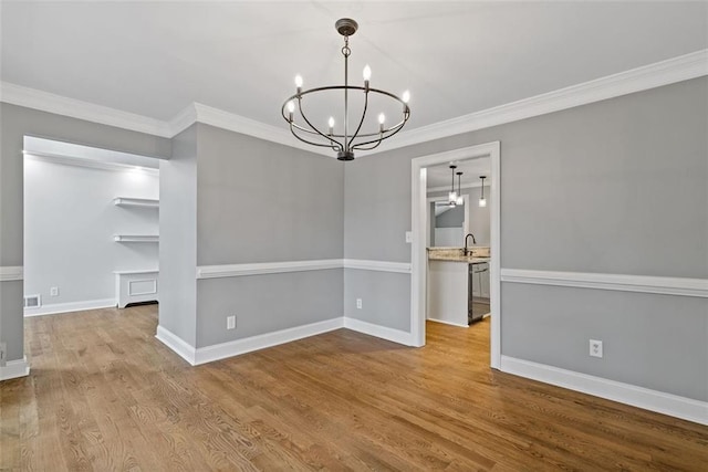 unfurnished dining area featuring light hardwood / wood-style floors, an inviting chandelier, crown molding, and sink