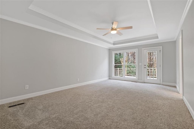 carpeted spare room featuring ceiling fan, ornamental molding, and a tray ceiling