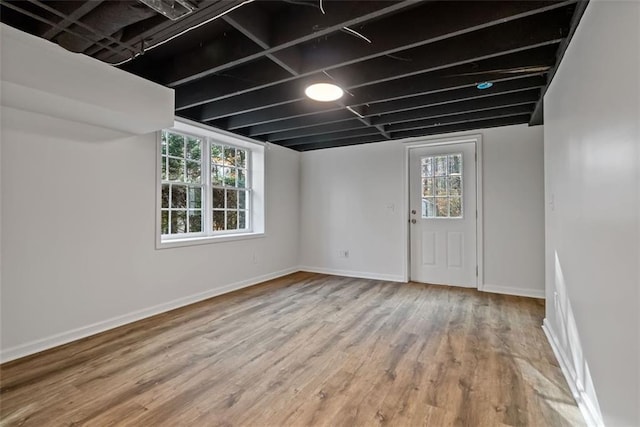 basement featuring plenty of natural light and hardwood / wood-style flooring