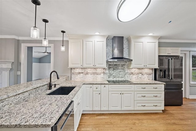 kitchen featuring black appliances, wall chimney exhaust hood, white cabinetry, and sink