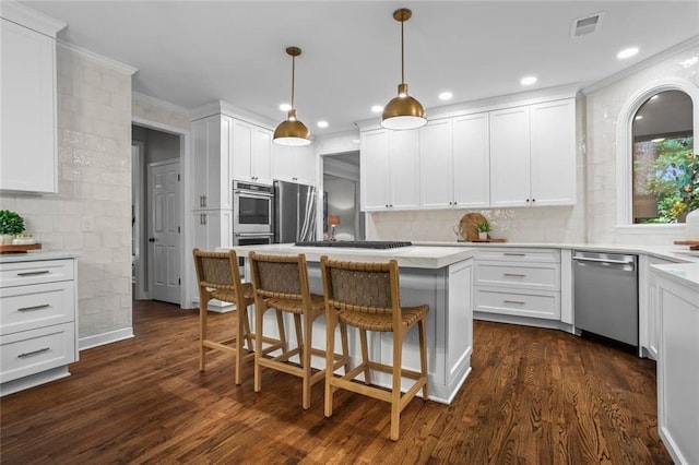 605 Linkside Holw, Alpharetta, GA 30005 - kitchen featuring appliances with stainless steel finishes, white cabinetry, dark wood-type flooring, a kitchen island, and a kitchen breakfast bar