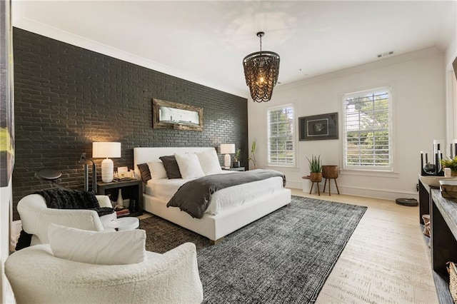 132 Grand Cres, Alpharetta, GA 30009 - bedroom featuring brick wall, ornamental molding, a chandelier, and light wood-style flooring