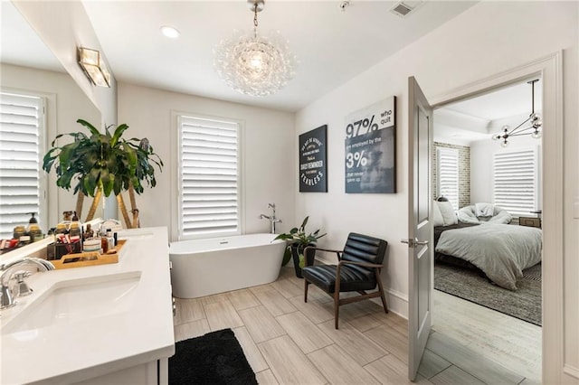 132 Grand Cres, Alpharetta, GA 30009 - ensuite bathroom featuring a chandelier, a soaking tub, double vanity, wood tiled floors, and recessed lighting