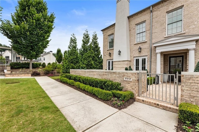 132 Grand Cres, Alpharetta, GA 30009 - view of side of property featuring a fenced front yard, brick siding, a gate, and a chimney