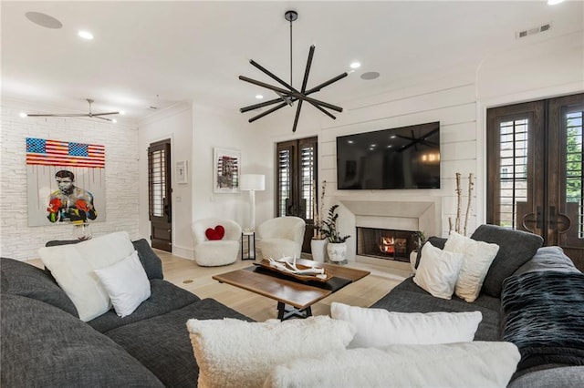 132 Grand Cres, Alpharetta, GA 30009 - living room featuring wood finished floors, a warm lit fireplace, recessed lighting, french doors, and crown molding