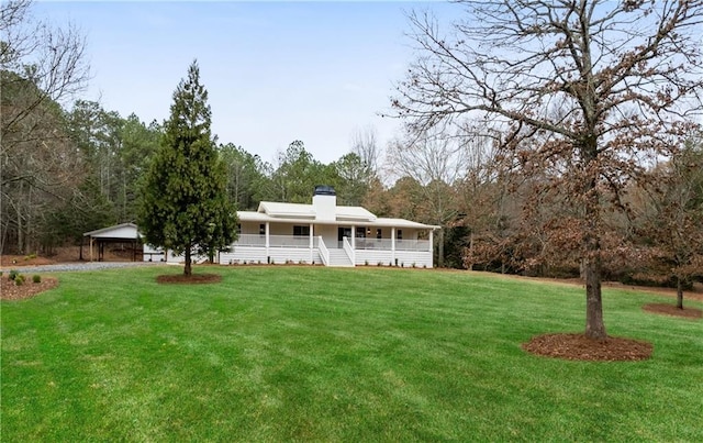 view of front of home with a porch, a chimney, and a front yard