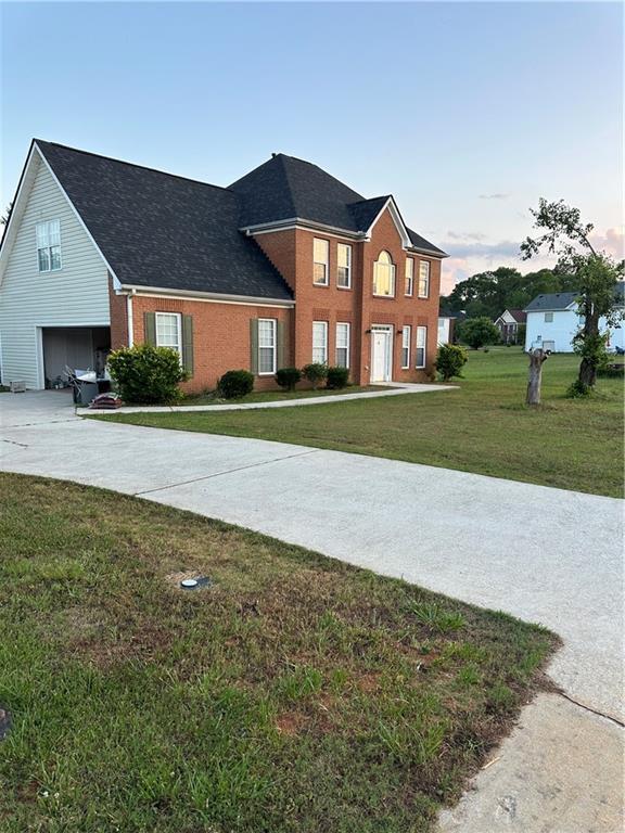 view of front of house featuring a garage and a yard