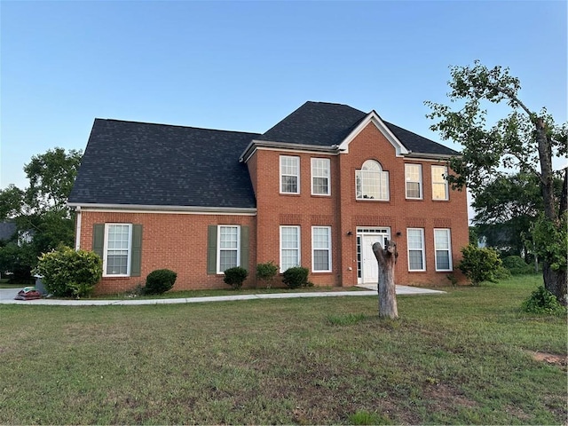 colonial home featuring a front lawn