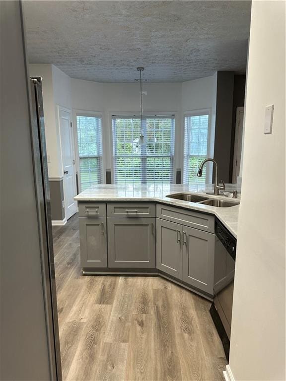 kitchen with hanging light fixtures, dishwasher, sink, and gray cabinetry