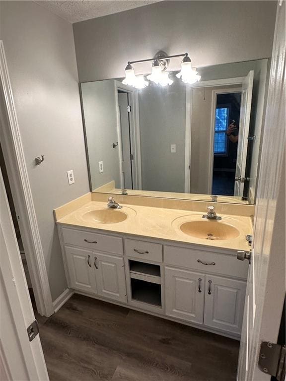 bathroom with hardwood / wood-style flooring, vanity, and a textured ceiling